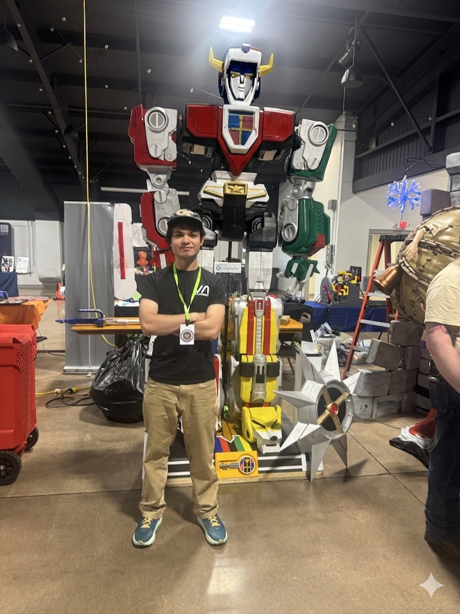Jacob standing beside a large fabricated robot at an engineering event